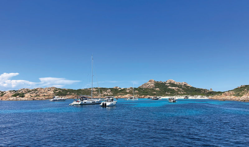 Boats in bay off Isola di Mortorio on sailing holiday in Sardinia